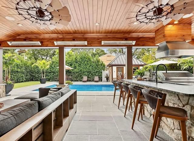 A large patio area with a swimming pool and a bar.