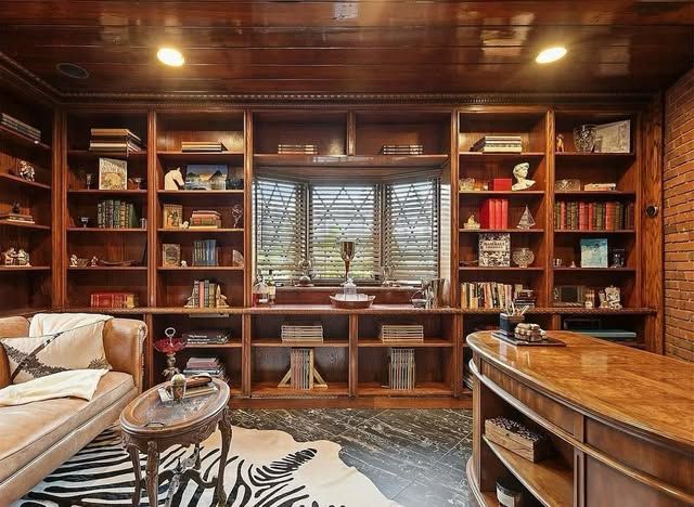 A living room with lots of bookshelves and a zebra print rug