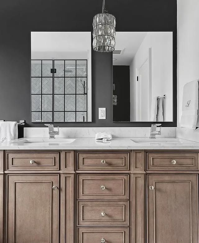 A bathroom with two sinks and a large mirror