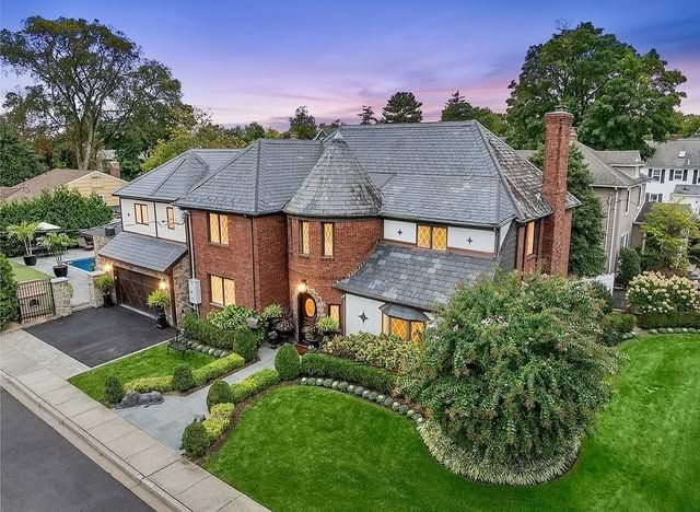 An aerial view of a large brick house with a slate roof