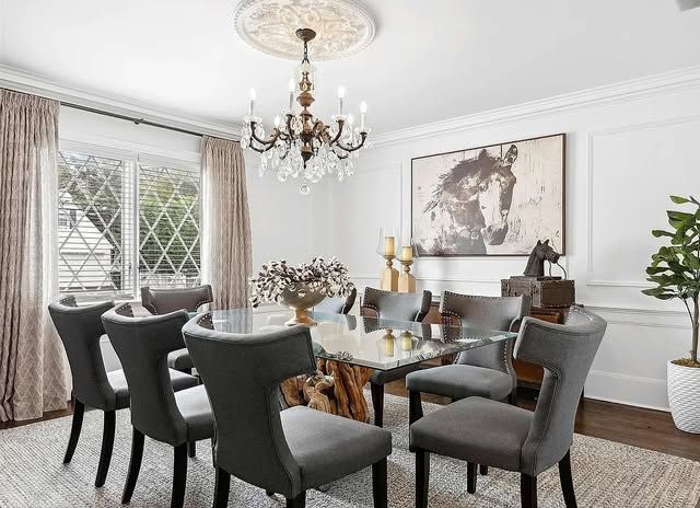 A dining room with a table and chairs and a chandelier.