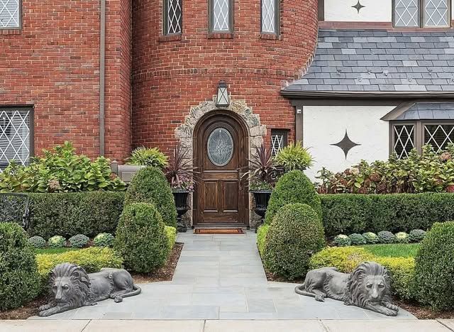 A brick house with two statues of lions in front of it