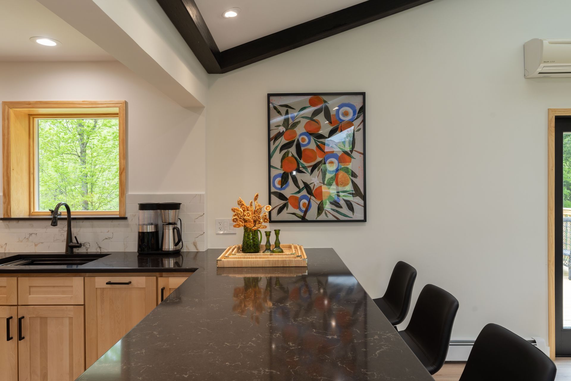 A kitchen with a large island and a painting on the wall.