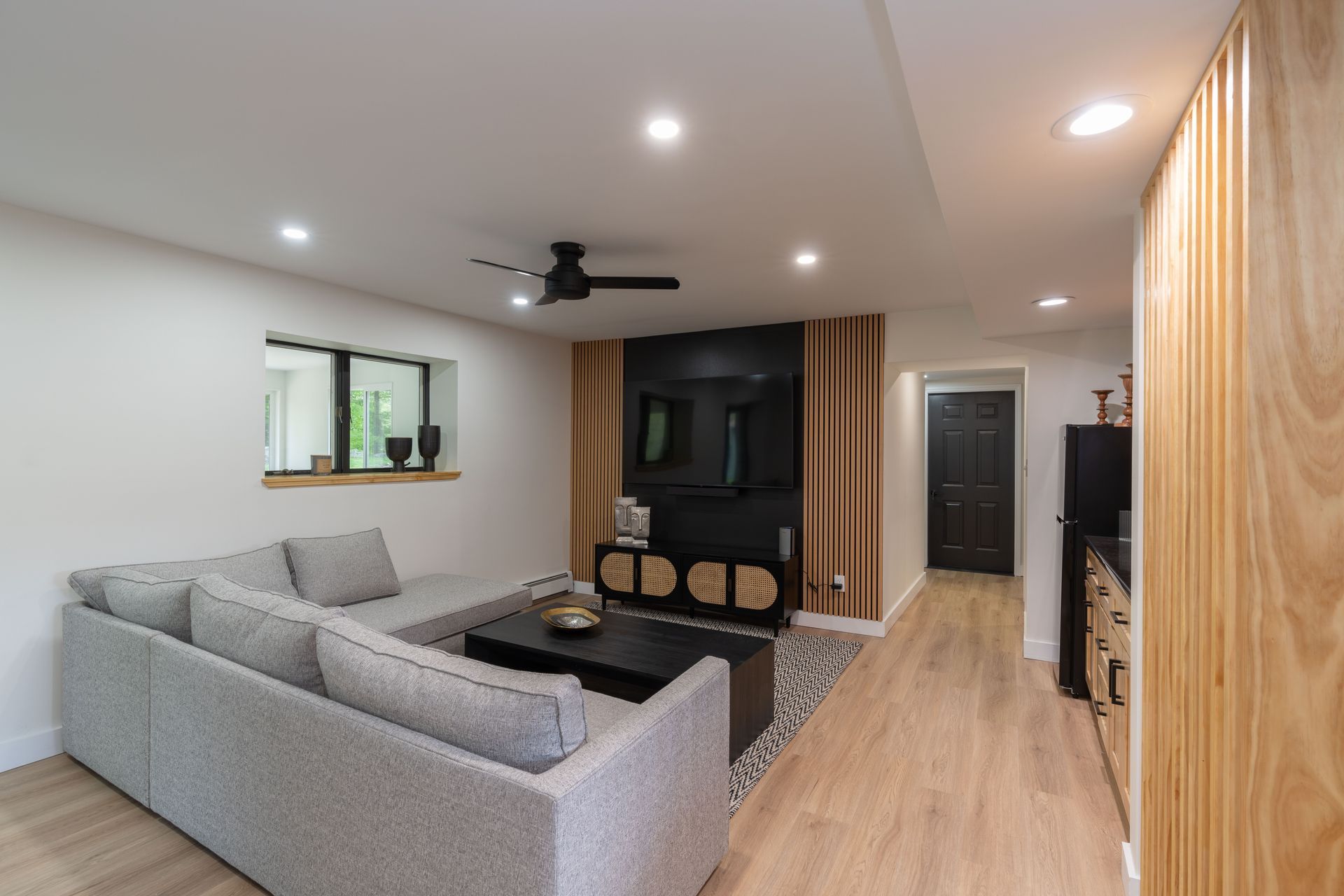 A living room with a couch , coffee table , and ceiling fan.