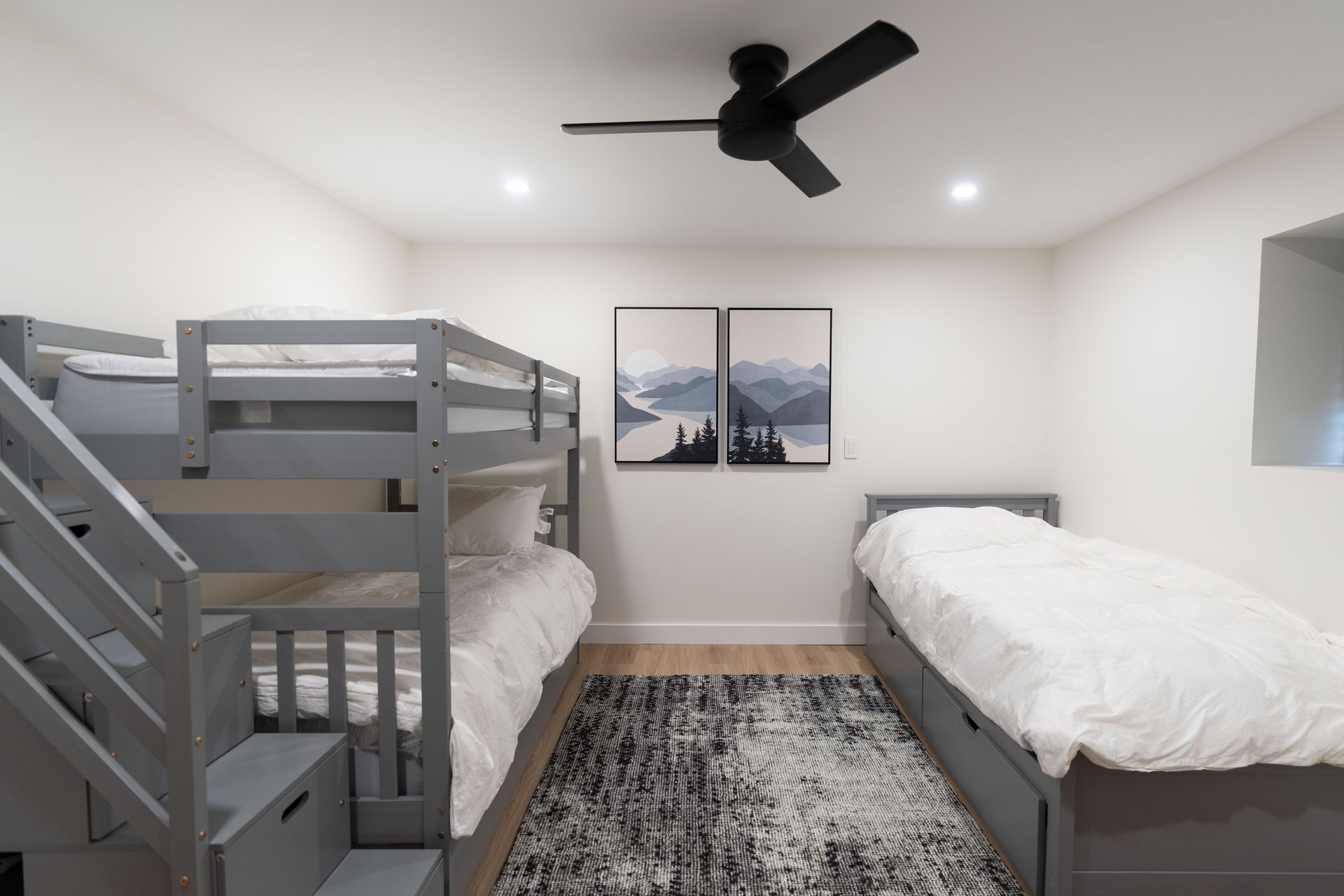 A bedroom with three bunk beds and a ceiling fan.