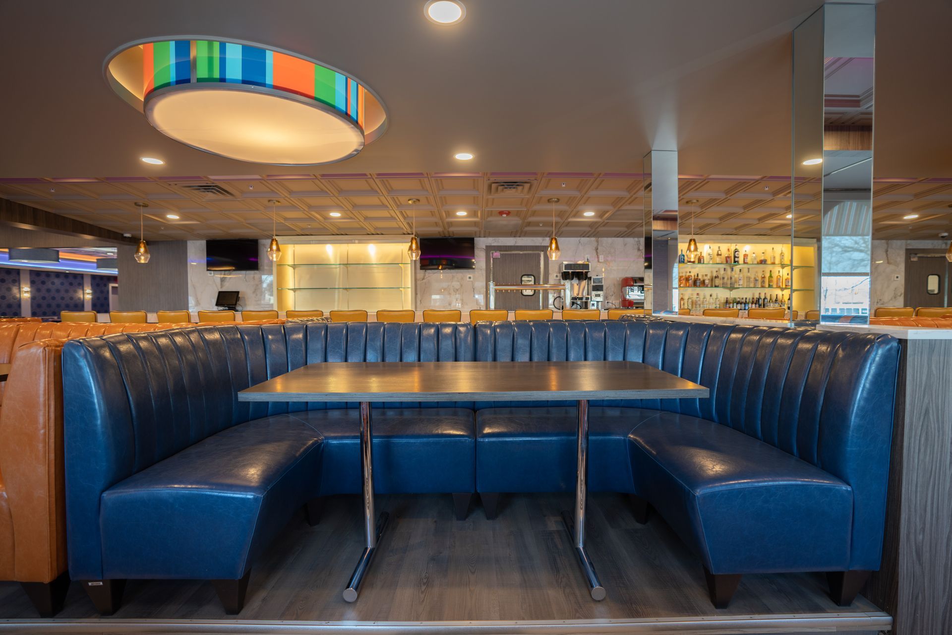 A restaurant with blue booths and tables in it.