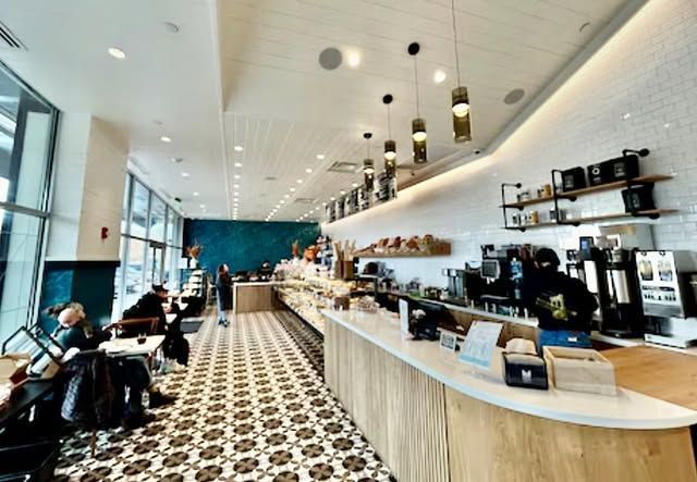 A restaurant with people sitting at tables and a long counter.