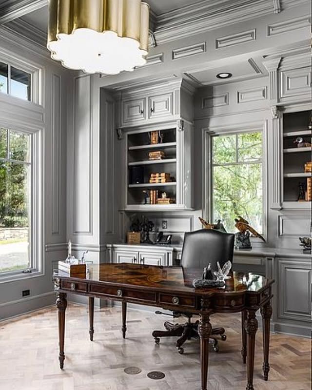 A home office with a desk , chair , and shelves.
