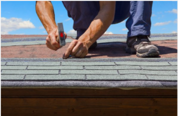 Man professionally replacing residential home roof in the summer in Cheyenne.