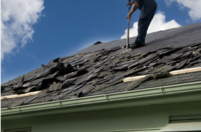 Roofer removing shingles off of commercial business in Cheyenne