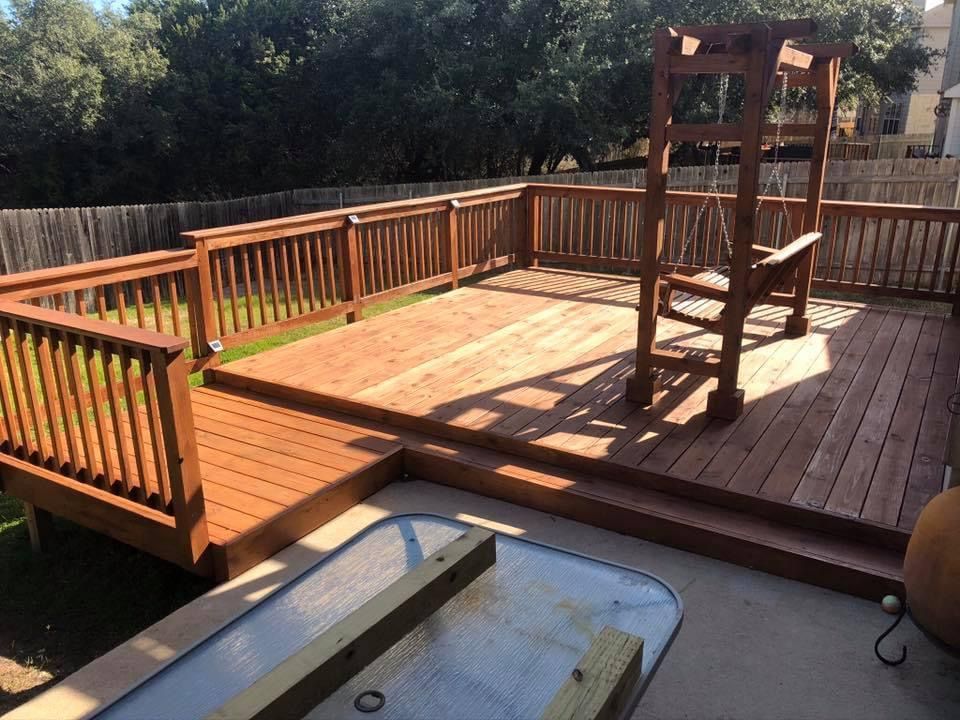 Wooden deck with railing and a chair lift beside a small pool, in bright sunlight.
