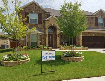 Brick suburban house with manicured lawn and Yard of the Month sign in front garden