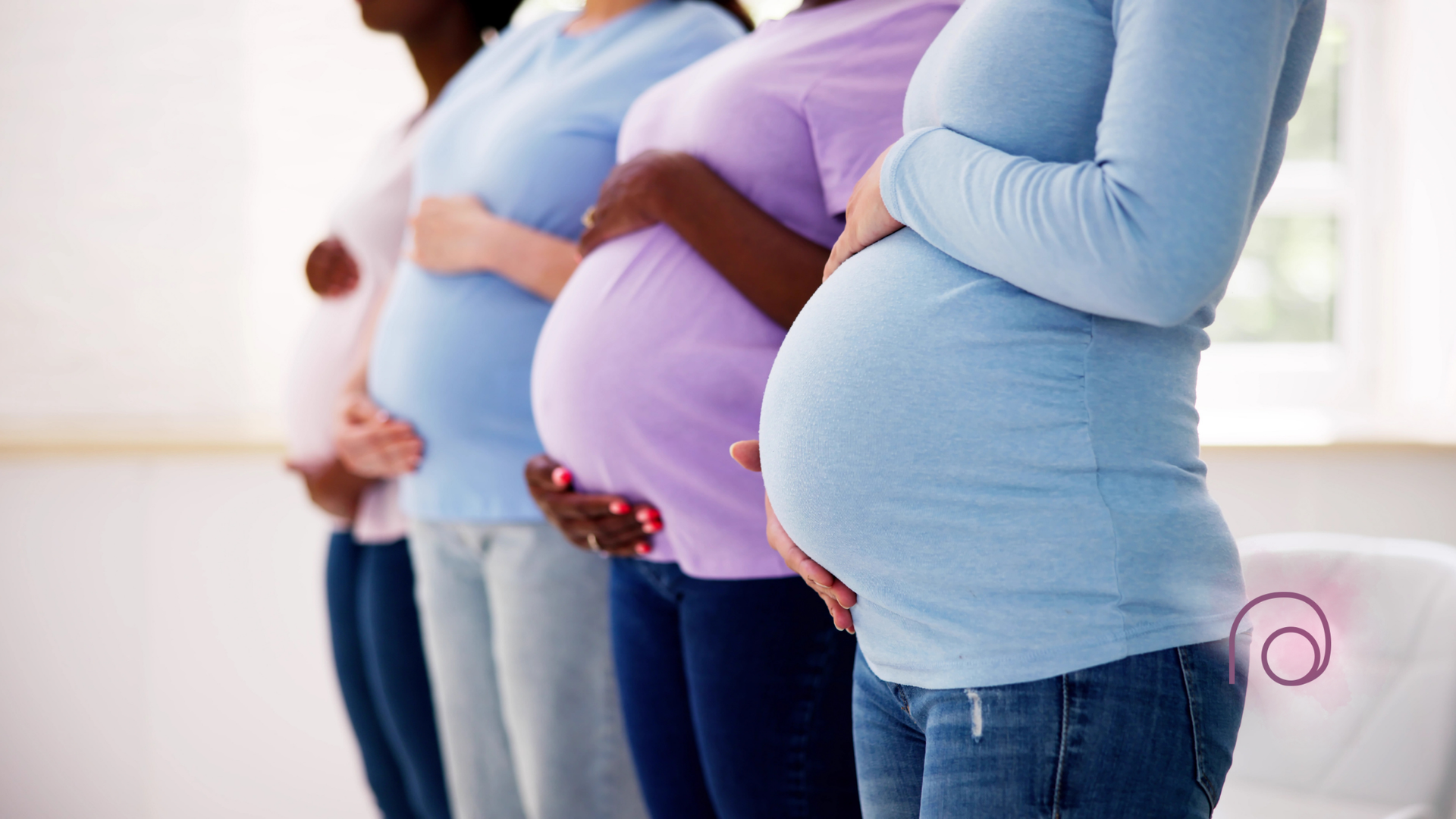 A group of pregnant women are standing next to each other holding their bellies.