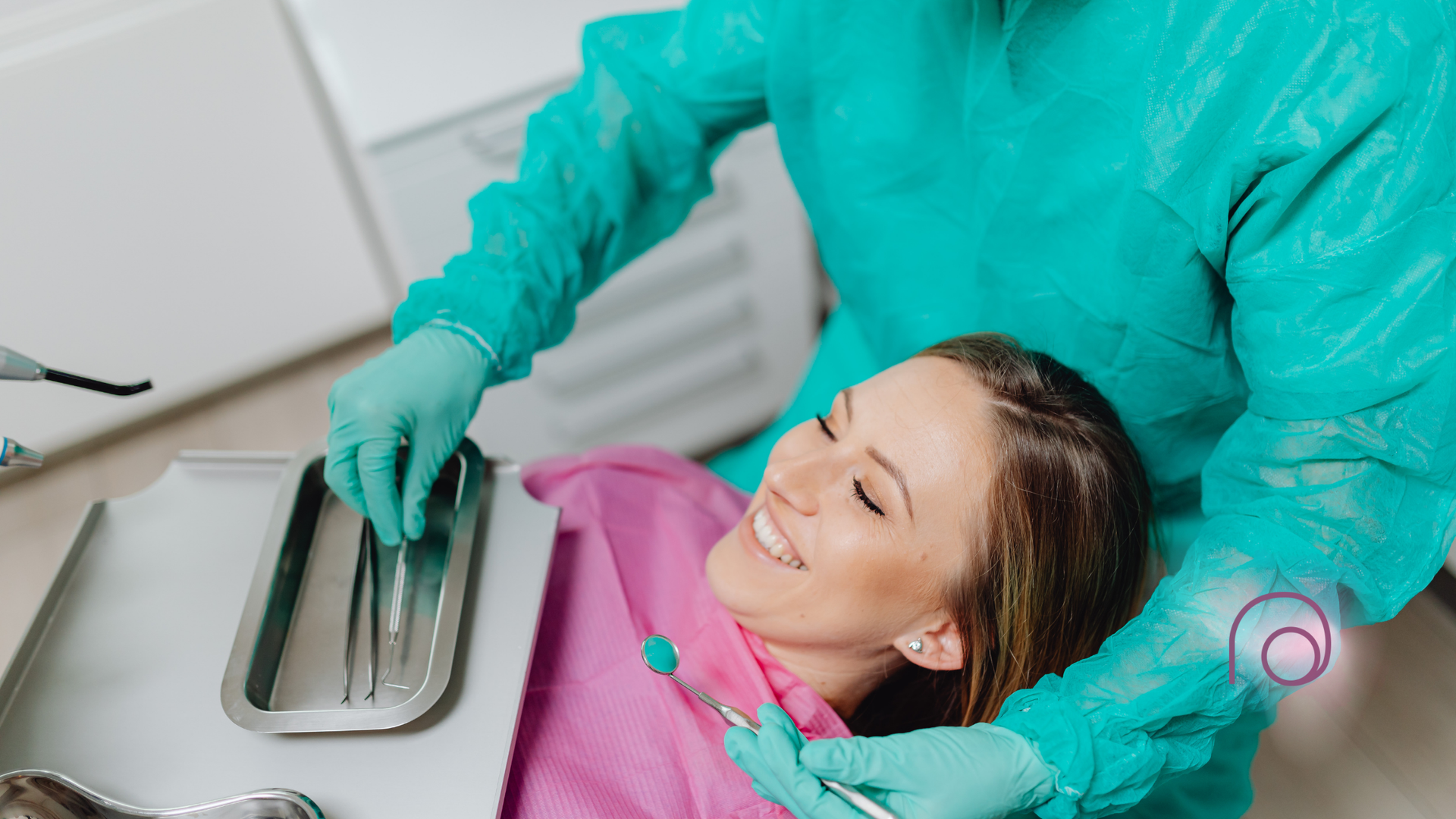 A woman is sitting in a dental chair while a dentist examines her teeth.
