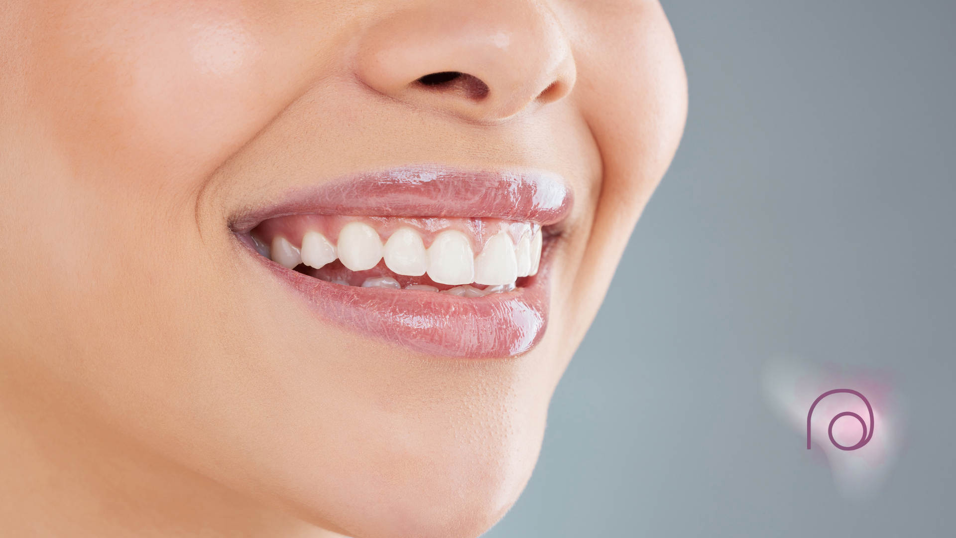 A close up of a woman 's mouth with white teeth.