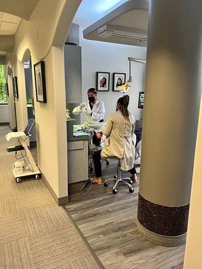 A dentist is working on a patient in a dental office.