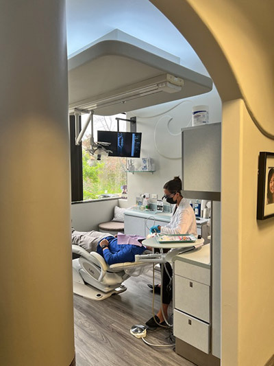 A dentist is working on a patient in a dental office.