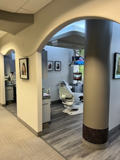 A dental office with a dental chair and pictures on the wall.