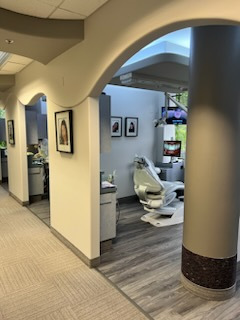 A dental office with a dental chair and pictures on the wall