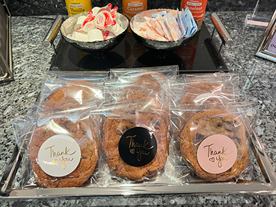 Three thank you cookies are sitting on a tray on a counter.