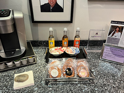 A tray of cookies and drinks on a counter next to a coffee maker.