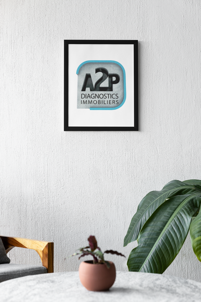 Un tableau encadré est accroché au mur à côté d'une plante en pot.