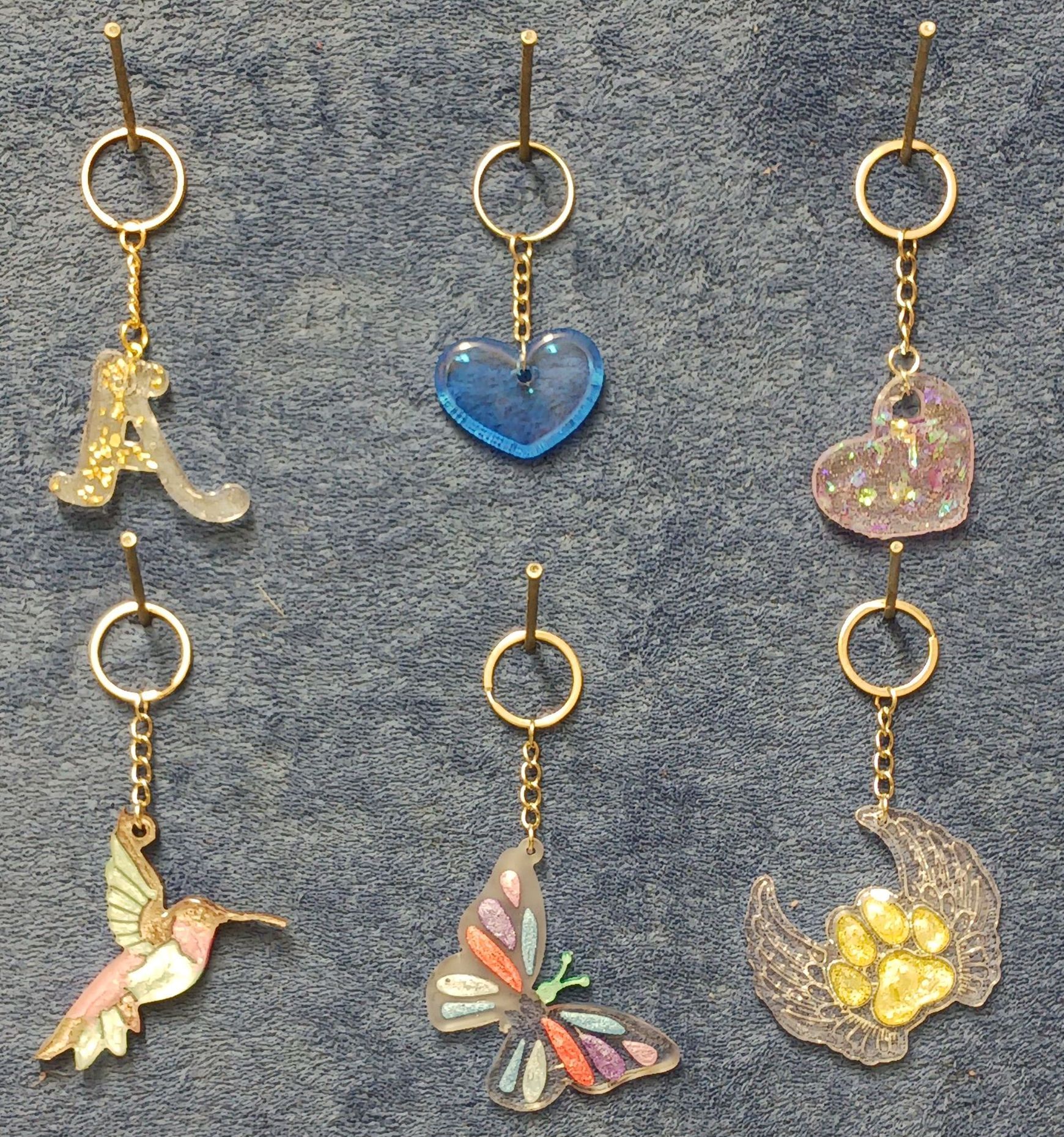 A hummingbird a heart a butterfly and a flower are among the keychains