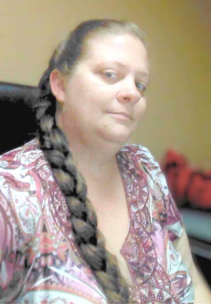 A woman with a braid in her hair is taking a selfie.