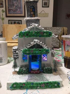 A gingerbread house is sitting on a table in a living room.