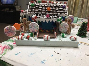 A gingerbread house decorated with candy and gingerbread men is sitting on a table.