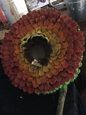 A flower made out of pinecones is sitting on a table.