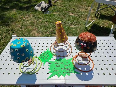 A table with a bunch handmade decorative mushrooms and a green signs
