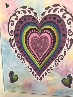 A paper craft of a layered rainbow mandalla heart 