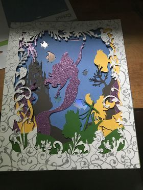 A picture of a mermaid with a castle in the background
