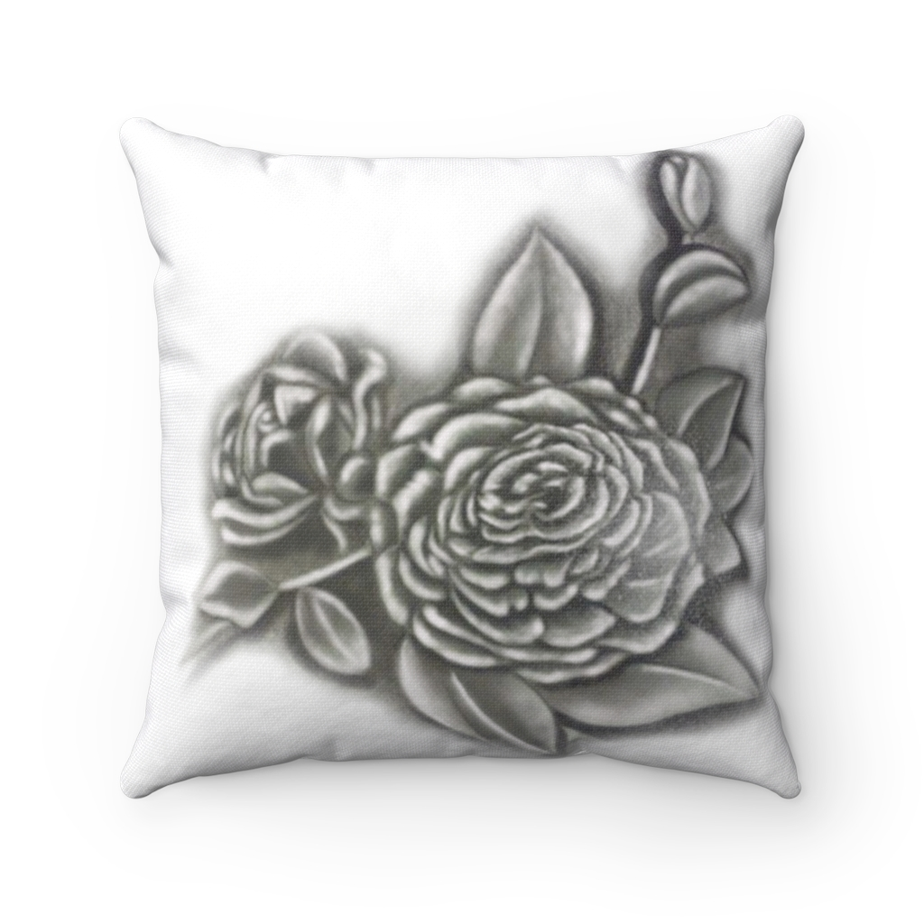 A black and white pillow with a drawing of a flower on it.