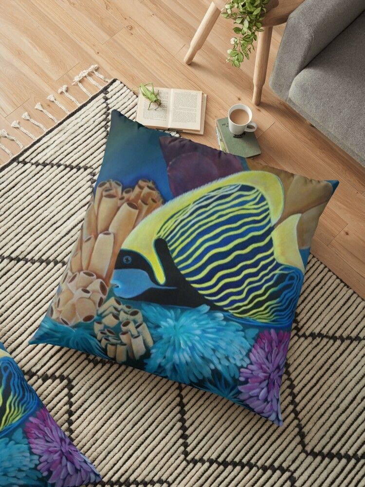 A floor pillow with a fish on it is on a rug in a living room.