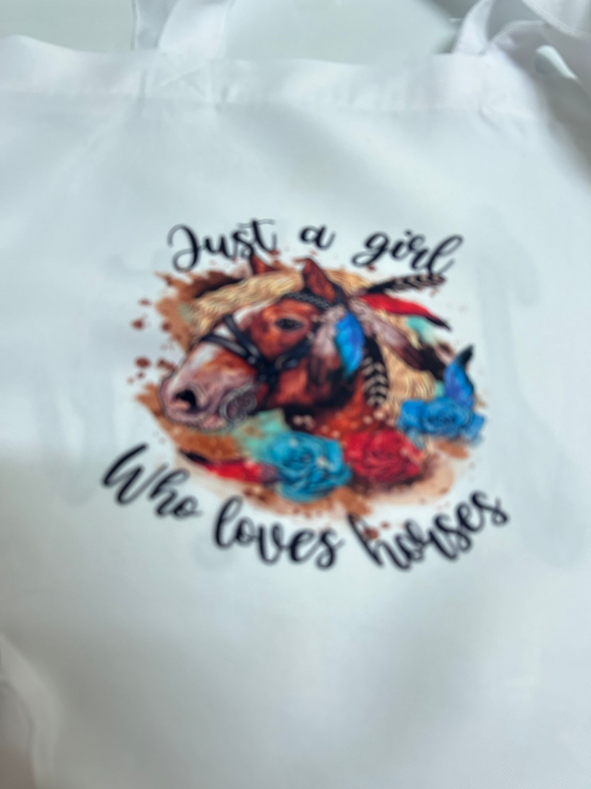 A white shirt with a horse on it that says 