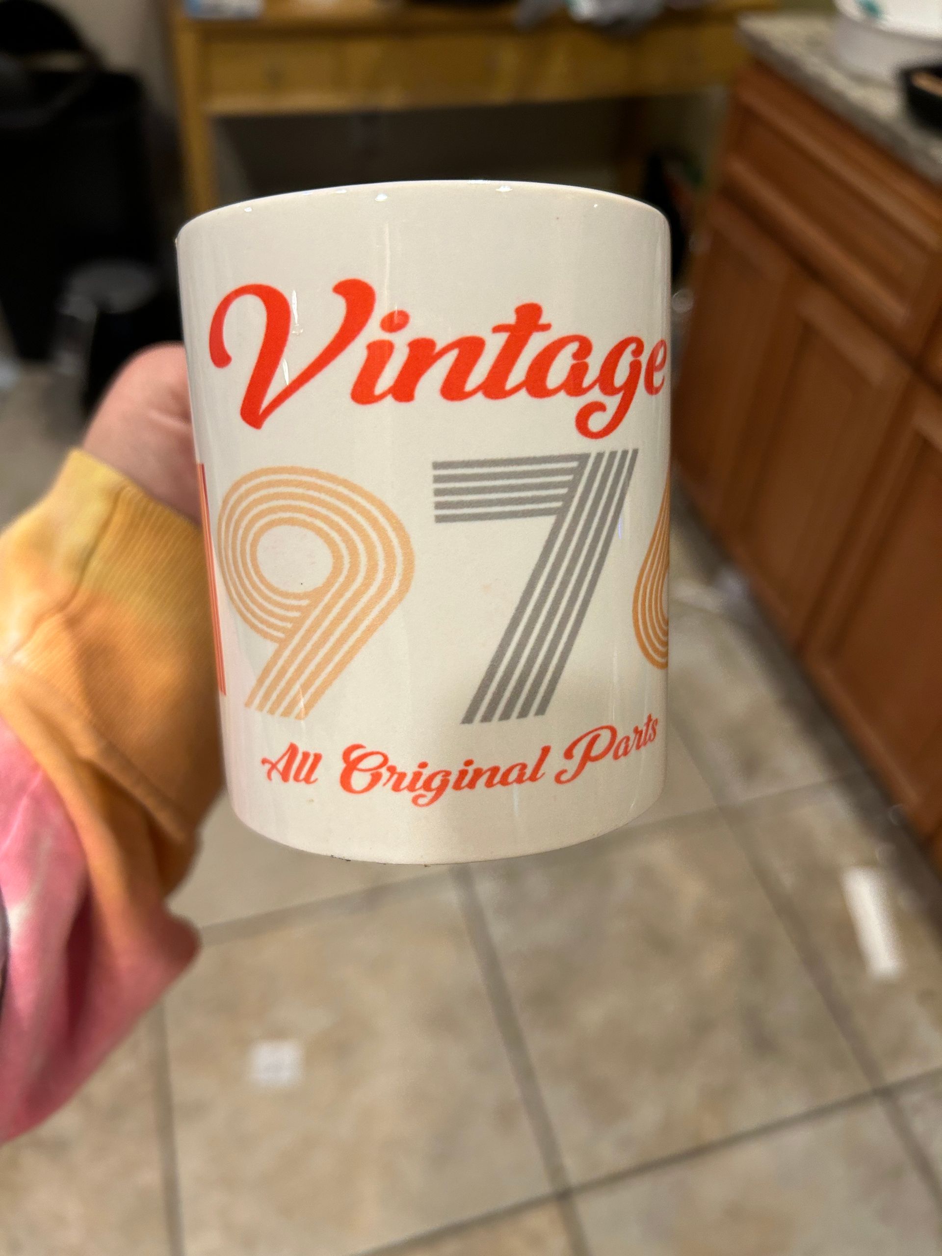 A person is holding a mug that says vintage 1976