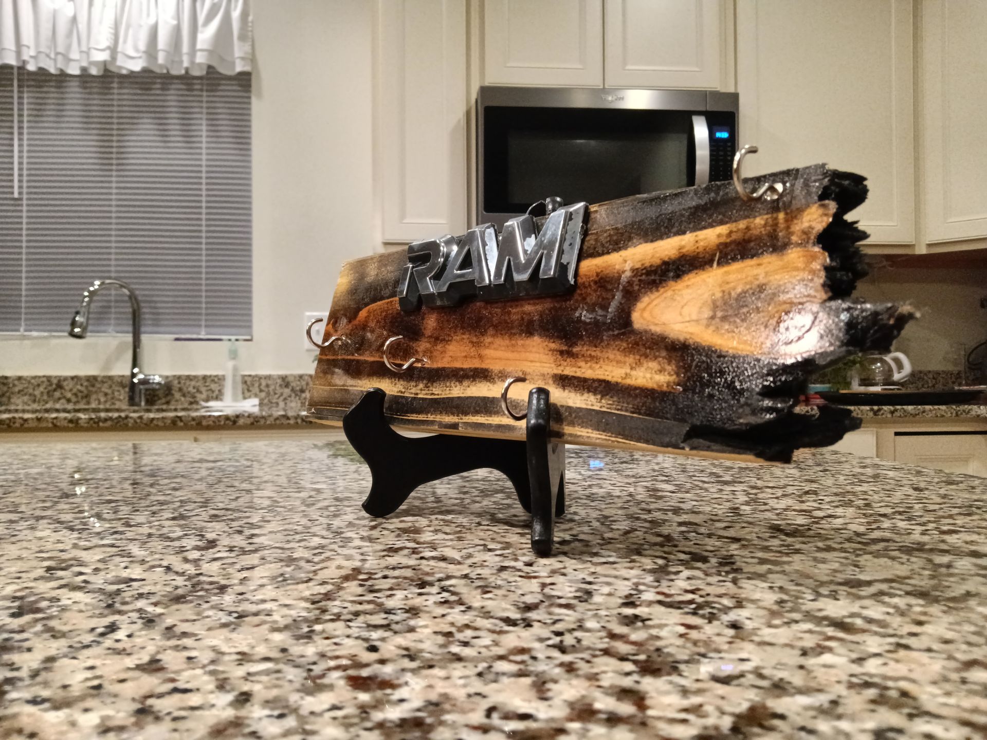 A piece of wood is sitting on top of a granite counter in a kitchen.