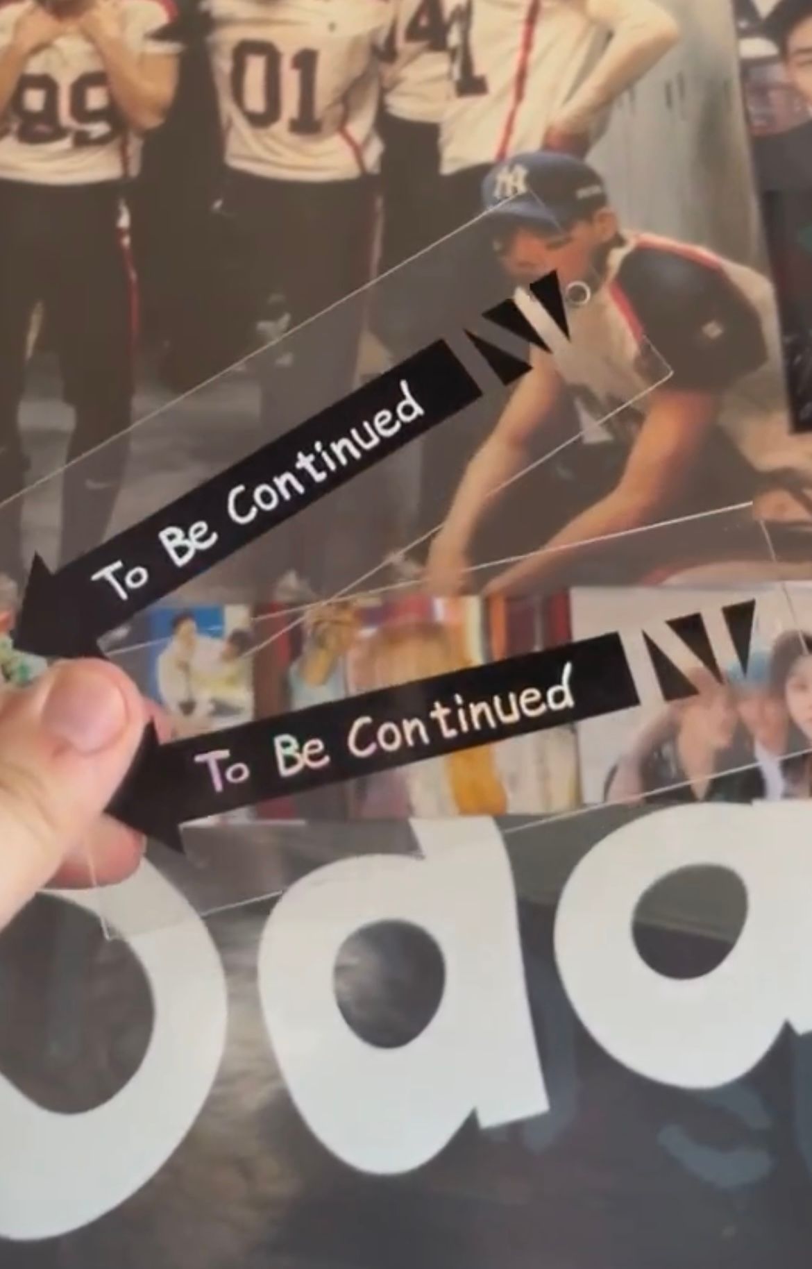 A person is holding a two transparent bookmarks that says to be continued