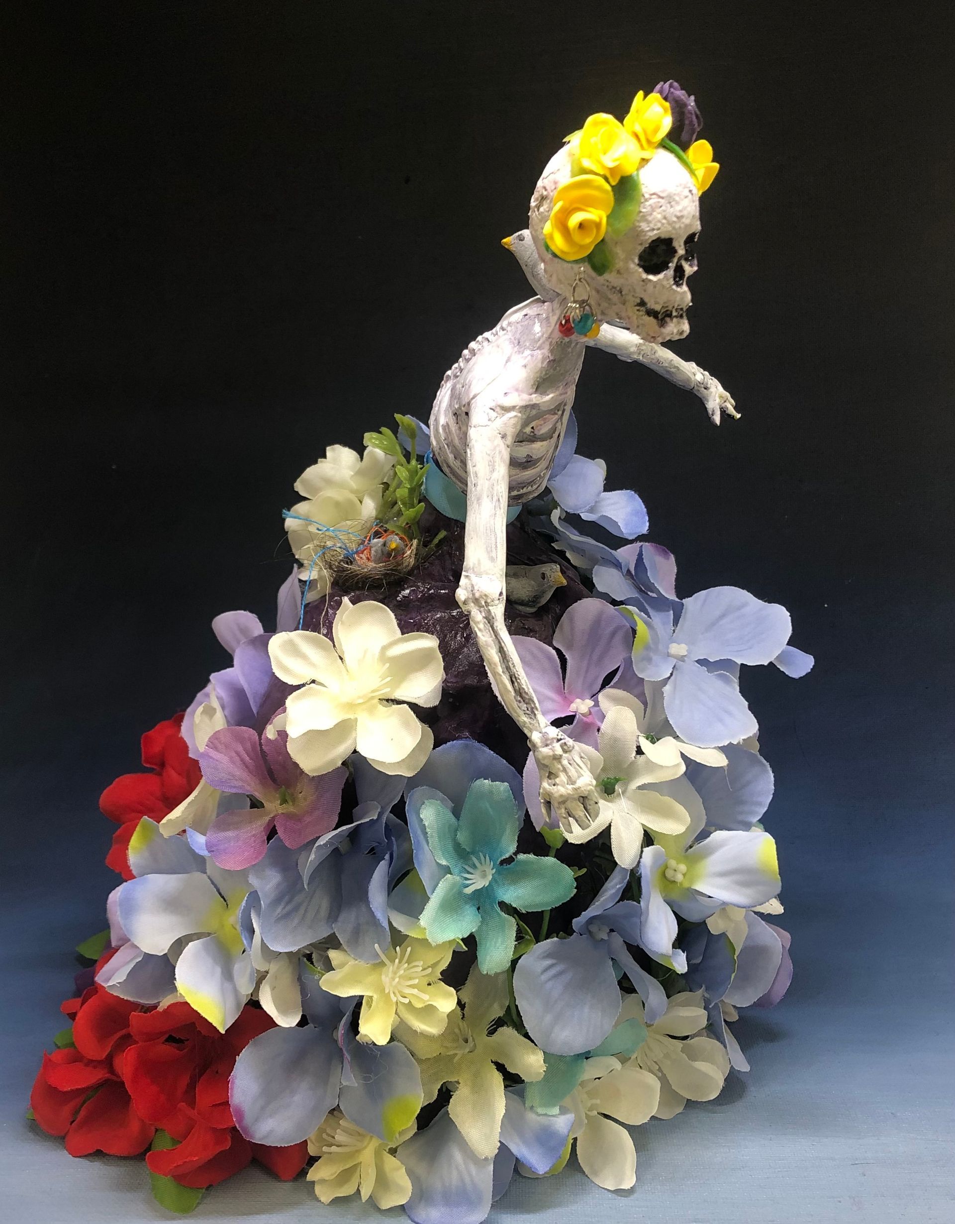 A skeleton is wearing a dress made of flowers