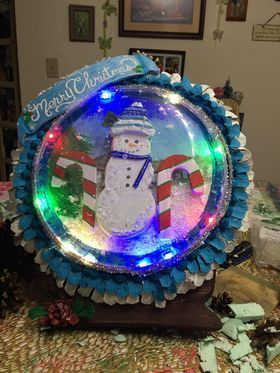 A snow globe with a snowman in it is sitting on a table.