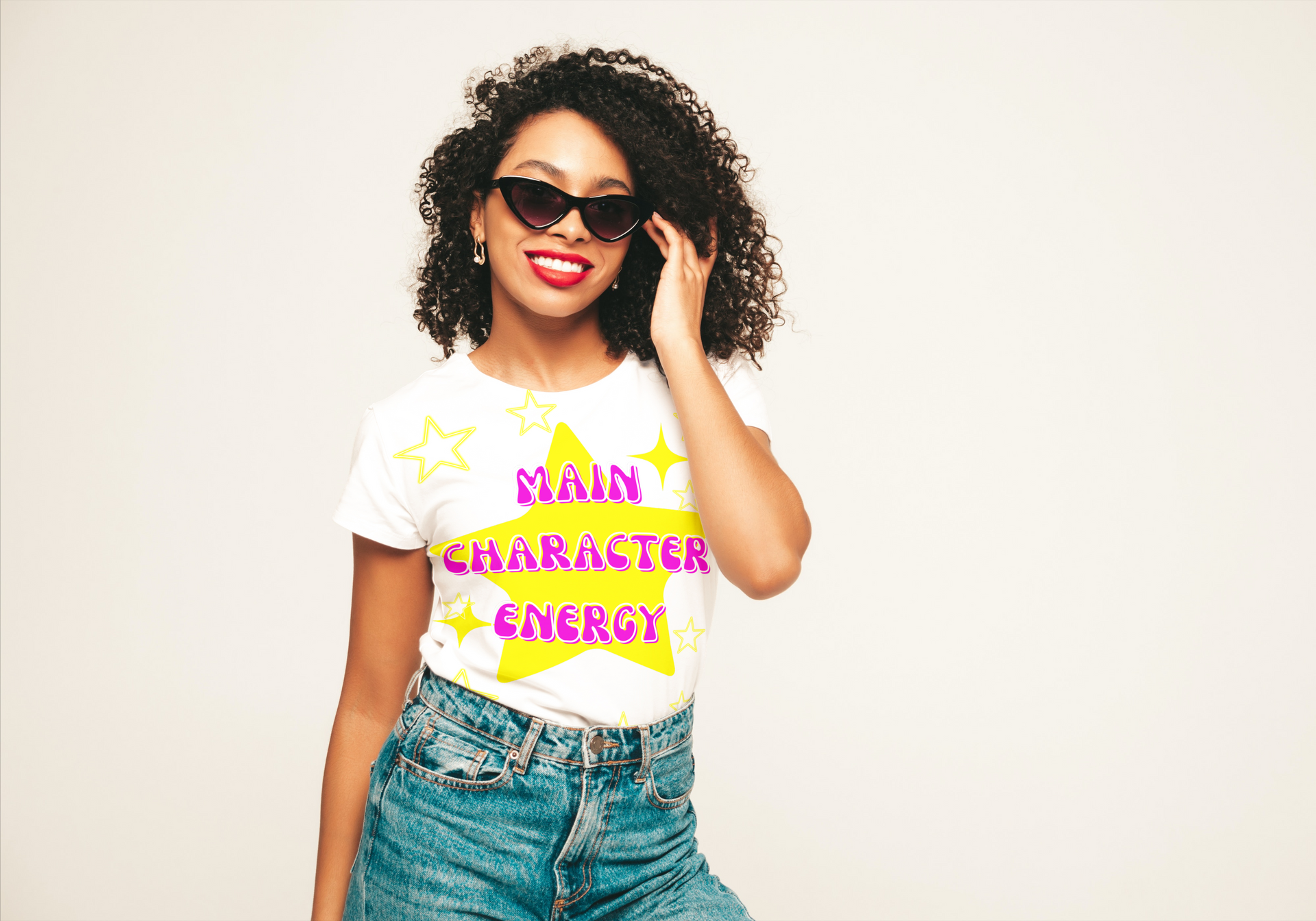 A woman wearing sunglasses and a white t-shirt with a star on it that says Main Character Energy.