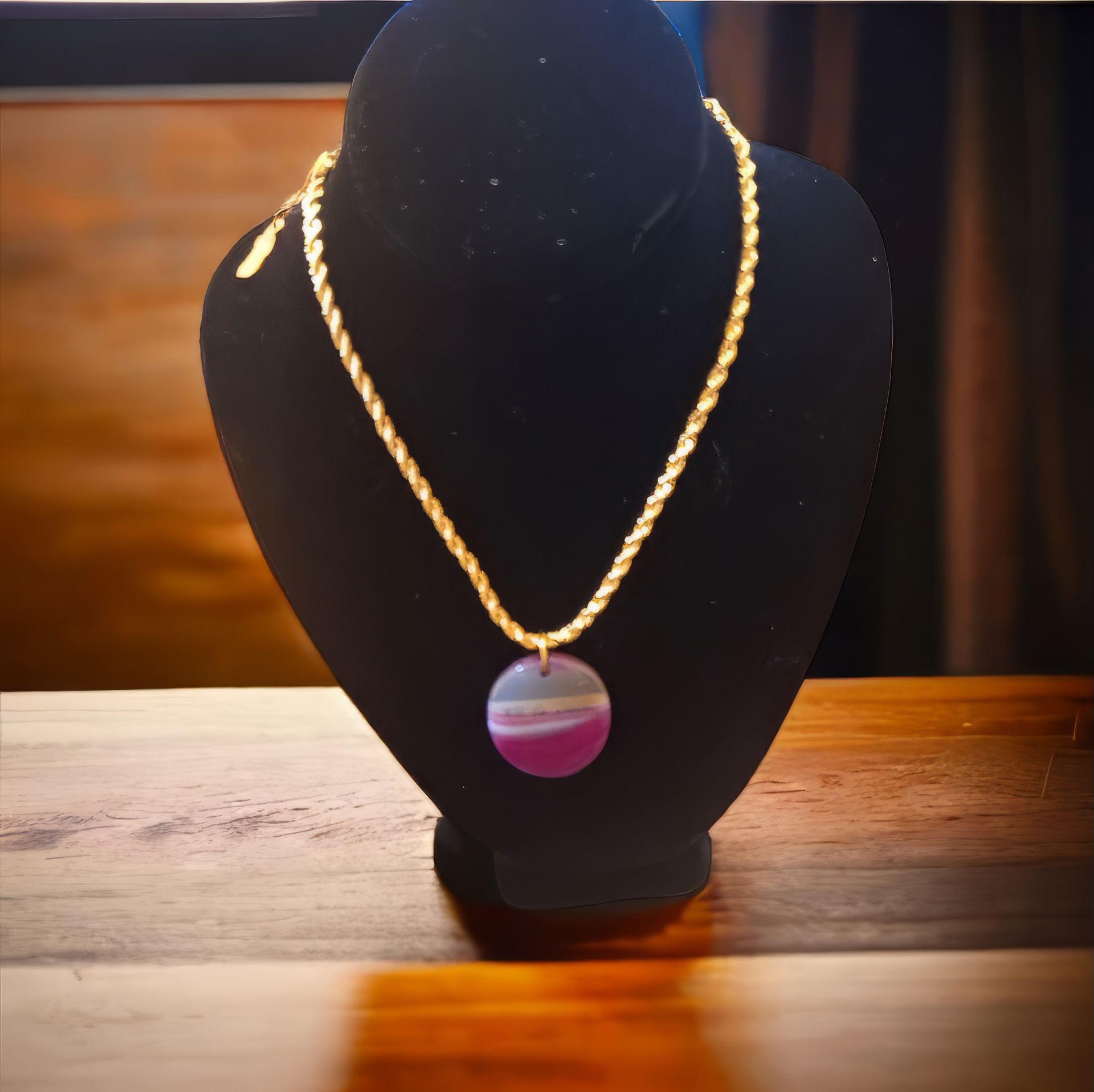 A necklace with a purple pendant is on a mannequin