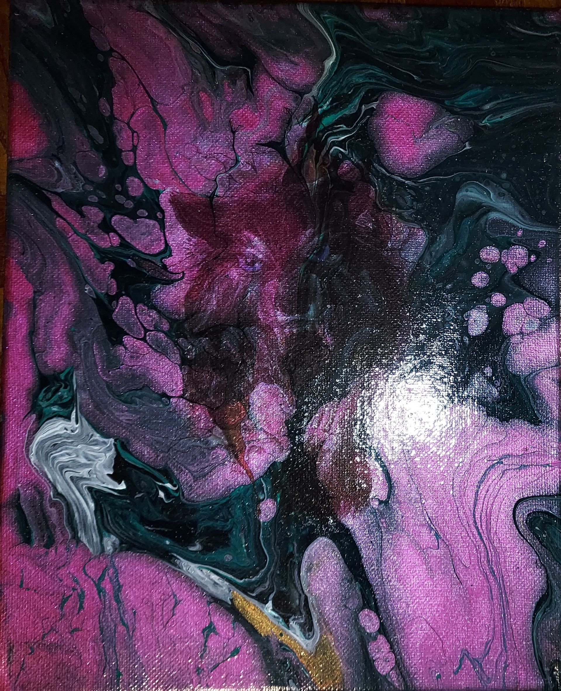 A close up of a purple and black painting on a canvas.