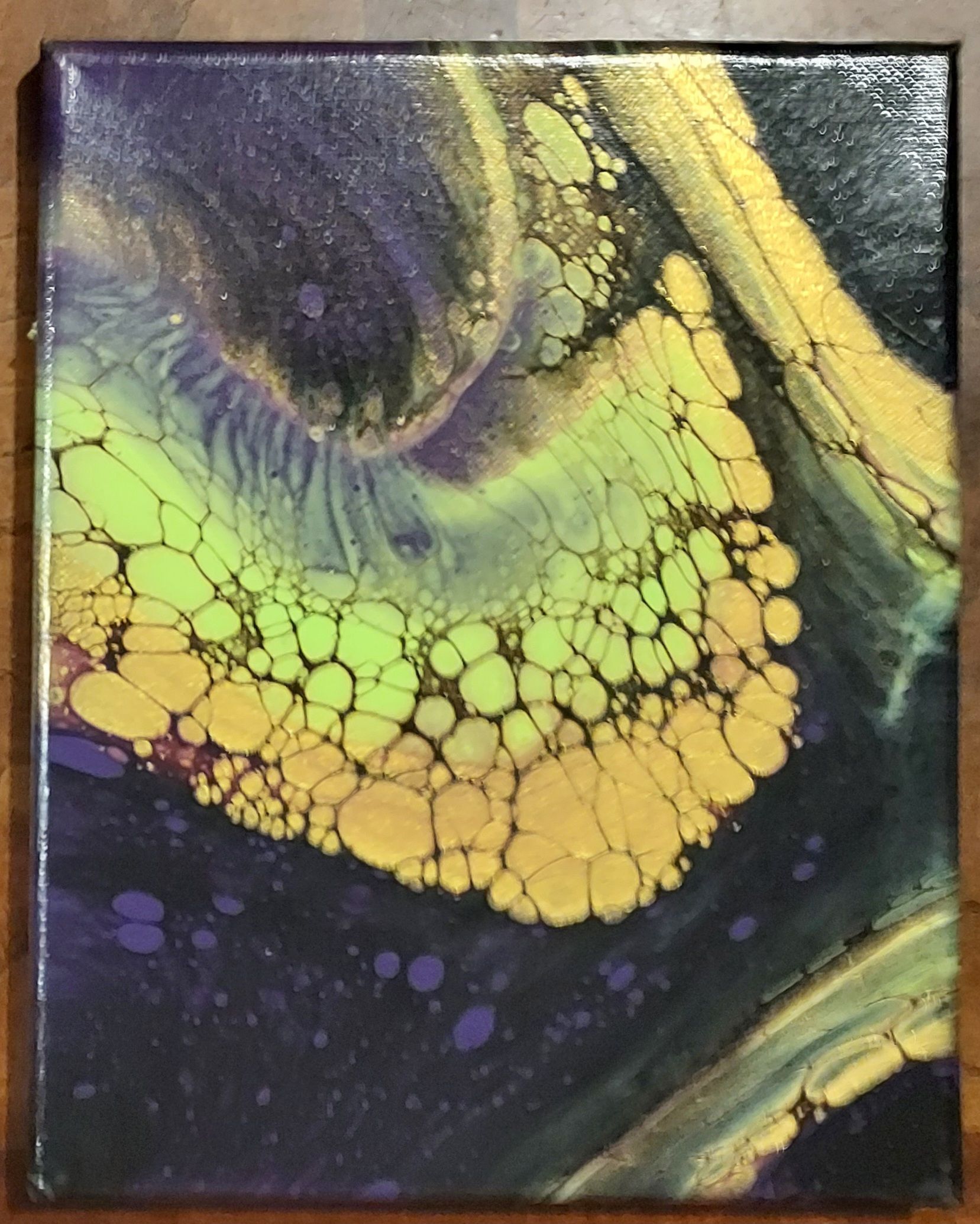 A yellow and purple painting on a wooden table