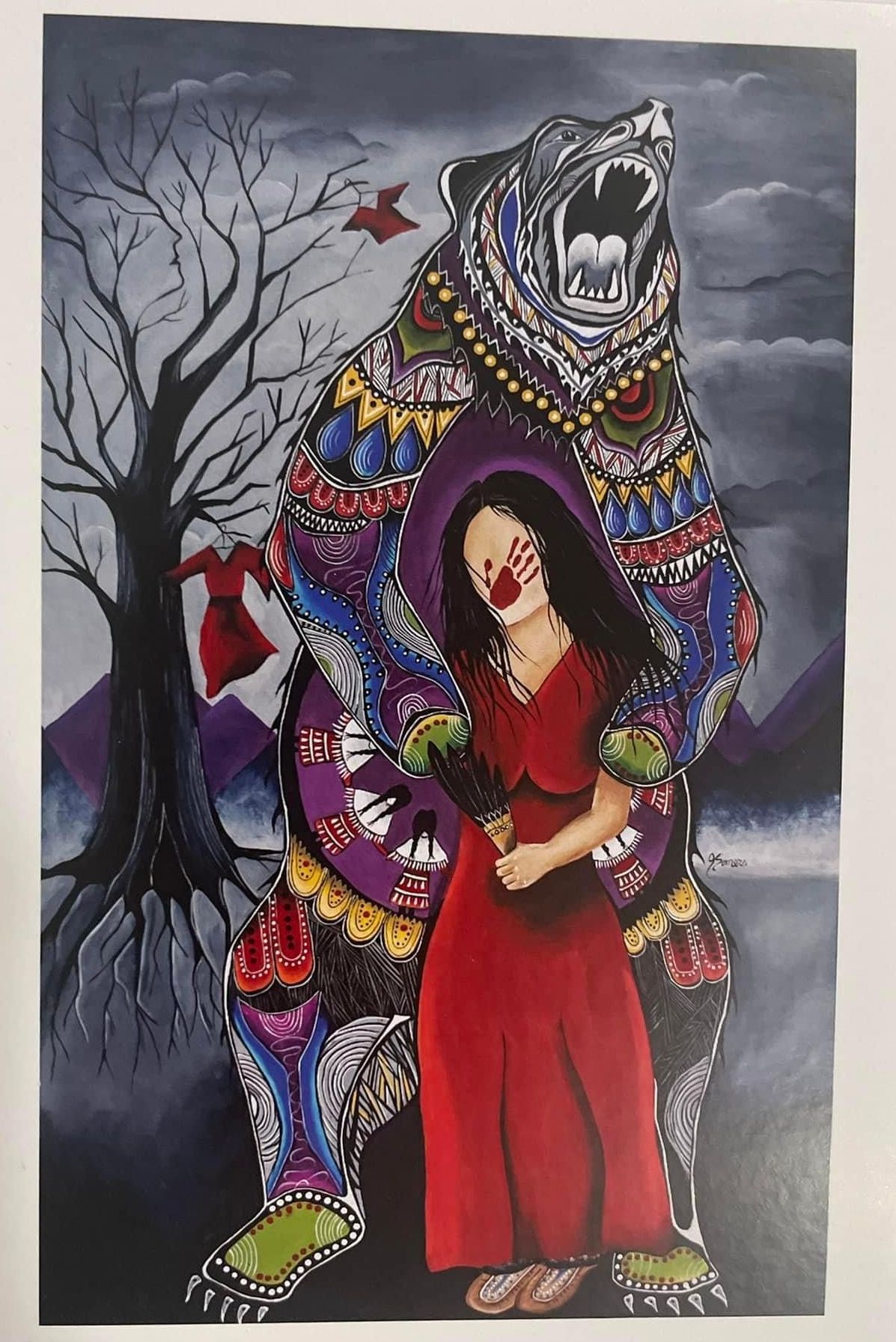 A woman in a red dress is standing next to a colorful bear.