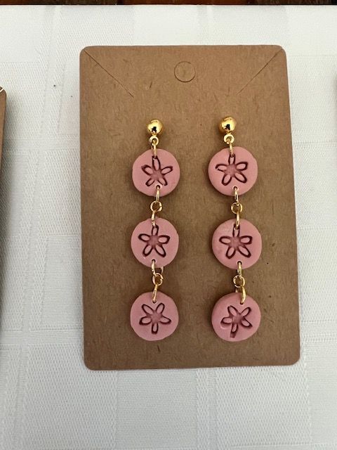 A pair of pink earrings with flowers on them