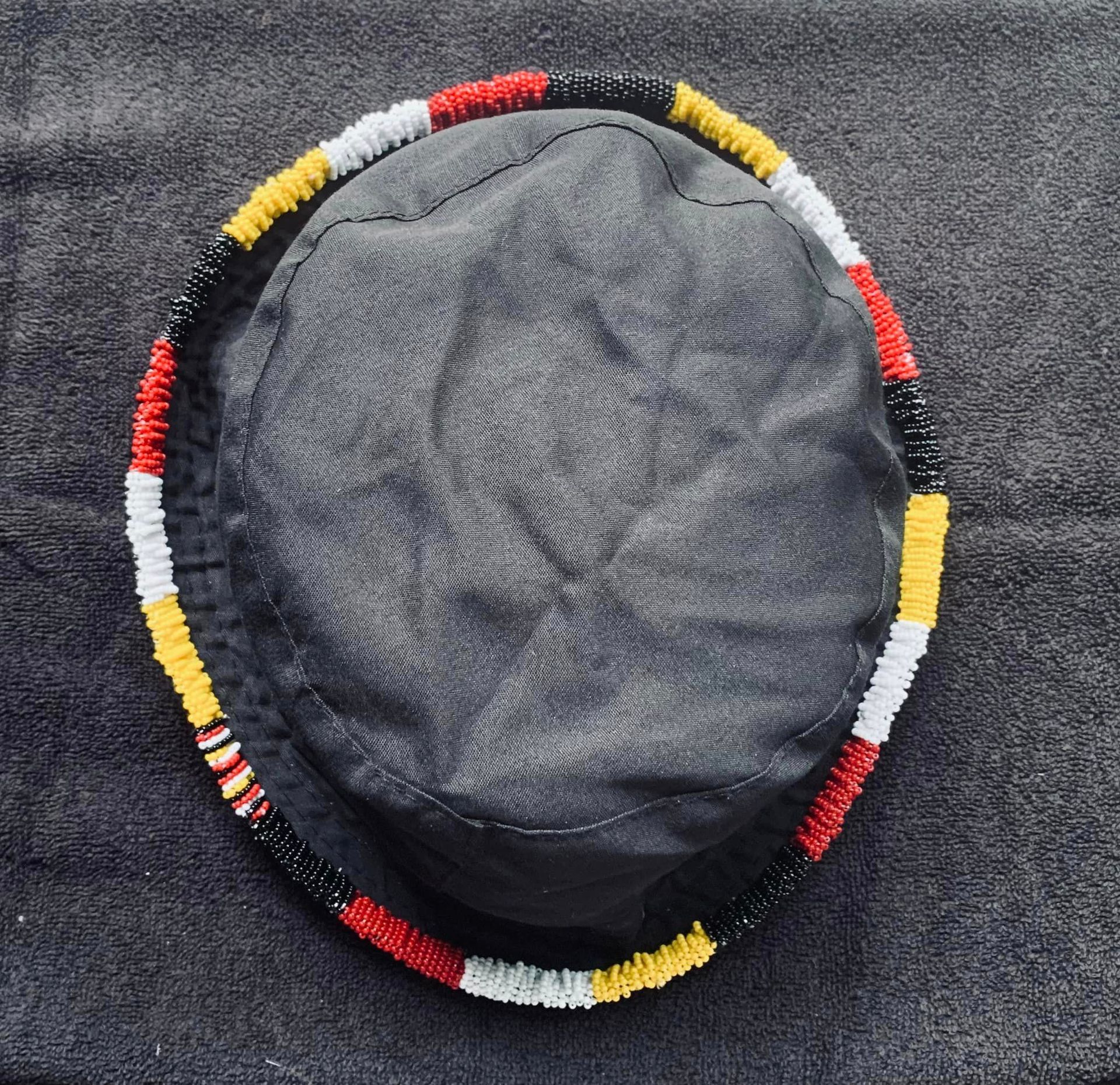 A black hat with red , white and yellow beads on it