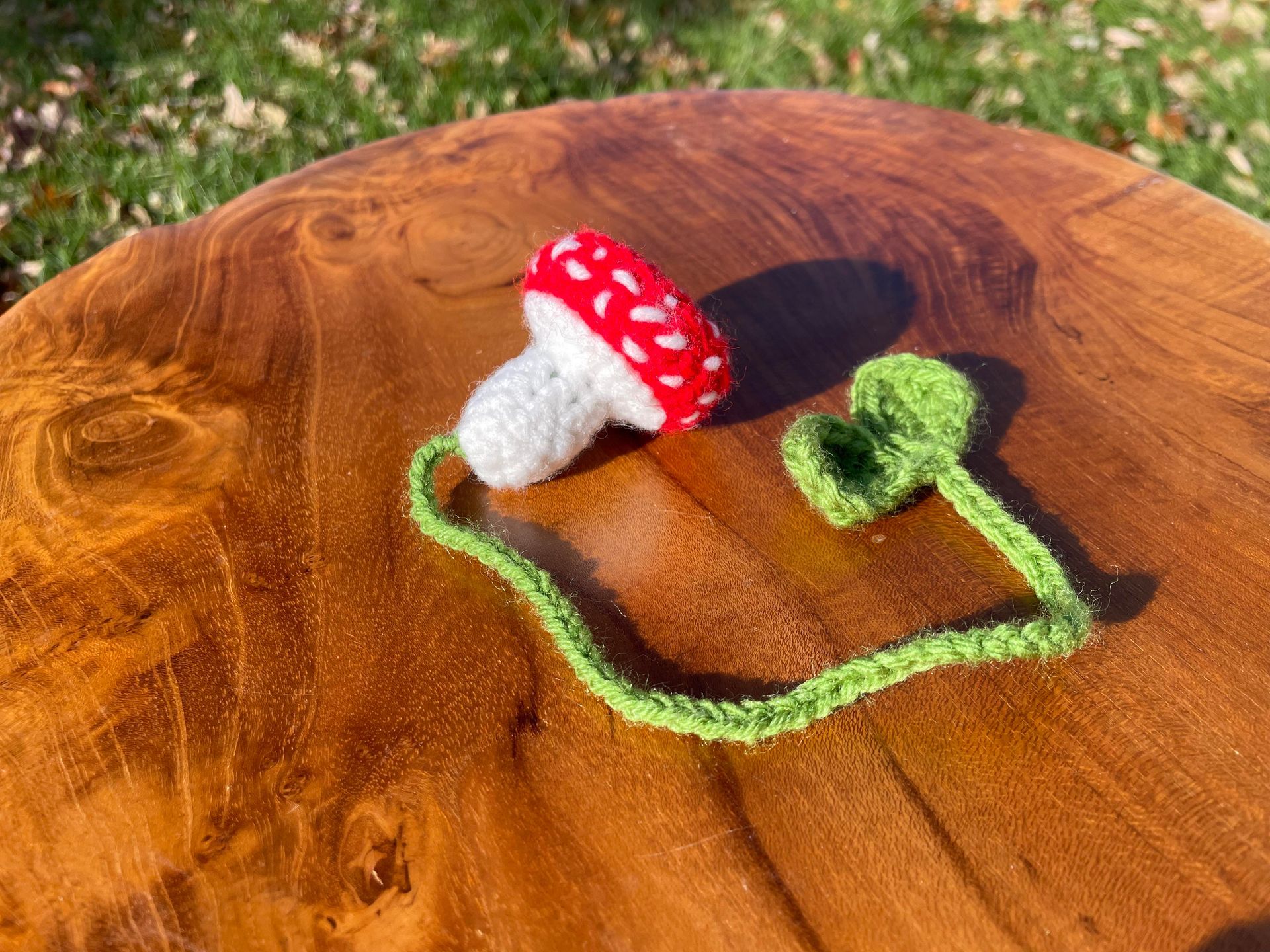 A crocheted mushroom is sitting on top of a wooden table.